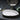 White ceramic vessel sink with dark base and center drain hole