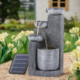 Outdoor solar fountain decor, dark gray stacked basins with small solar panel on ground.