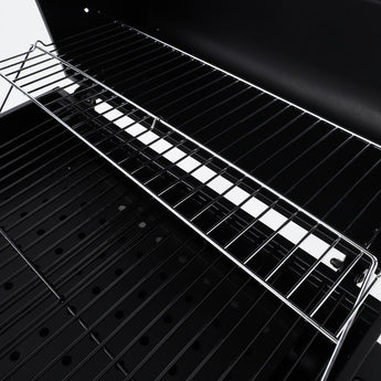 Close-up of charcoal BBQ cooking grate and firebox bars over the grill surface
