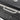 Stainless steel handle on the black grill lid of a 160 cm charcoal barrel grill