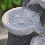 Close-up of upper bowl and water stream on dark speckled 4-tier fountain