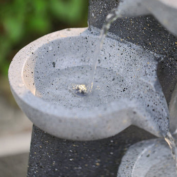 Close-up of upper bowl and water stream on dark speckled 4-tier fountain