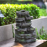 Faux rock garden fountain on tabletop style surface, multi-tier water flow detail.