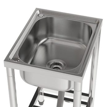 Stainless steel sink bowl with drain strainer opening on square rim frame.