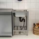 Stainless steel sink unit with shelf frame and U-shaped drainpipe underneath.