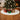 White plush Christmas tree skirt with oval fuzzy pile and gift boxes on top