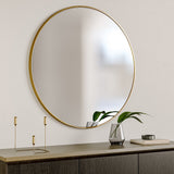 Round wall mirror with gold metal frame, reflecting surface
