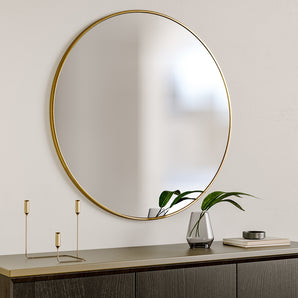 Round wall mirror with gold metal frame, reflecting surface