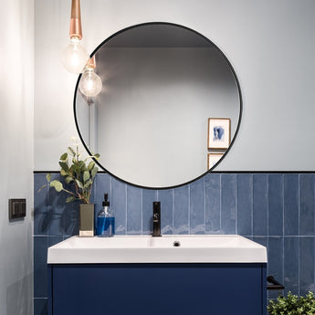 Round bathroom mirror with black metal frame and clear reflective glass