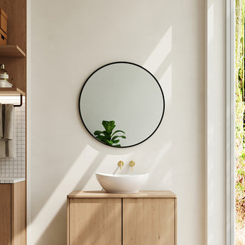 Round bathroom wall mirror with black frame and clear reflective glass