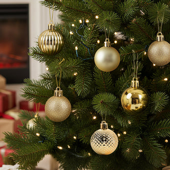 Gold-tone Christmas ball ornaments with mixed finishes hanging on a tree