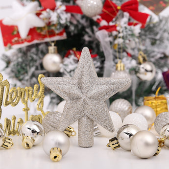 Glitter star tree topper with assorted white, silver, and gold Christmas ornaments