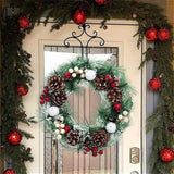 Snow-flocked Christmas wreath with pinecones, red berries and white baubles