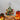 Mini artificial Christmas tree with silver star topper, warm lights, pinecones and red ornaments