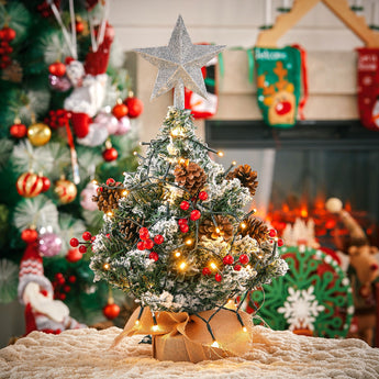Mini artificial Christmas tree with silver star topper, warm lights, red berries
