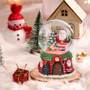 Santa Claus snow globe ornament with house scene under clear glass dome, green base