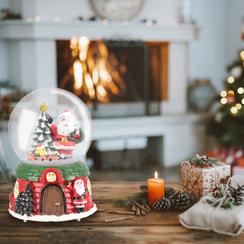 Santa Claus snow globe ornament with red house and Christmas tree inside clear glass dome
