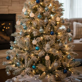 Christmas ball ornaments on full tree: white, silver, and blue hanging baubles