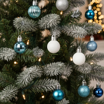 Christmas ball ornaments on fir branches: blue, white, and silver textured baubles
