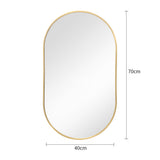 Gold oval wall mirror with rounded top and bottom, thin metal frame and reflective glass.