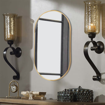 Gold oval metal wall mirror with slim frame and clear reflective glass