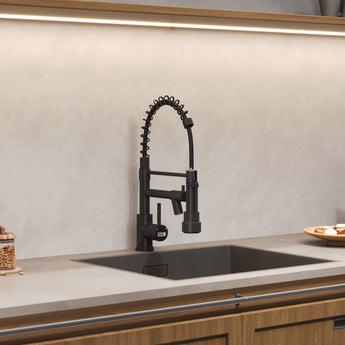 Black kitchen faucet with pull-down sprayer, mounted on countertop sink