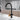 Black single-handle kitchen faucet with tall curved spout and gold-toned control lever