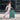 Woman carrying dark green cosmetic trolley case with telescoping handle and casters