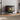 Black freestanding electric fireplace heater with enclosed flame window and logs