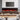 Black wall electric fireplace with red flame over stone log bed and mantle.