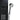 Chrome handheld shower head with spray face and coiled hose on black panel