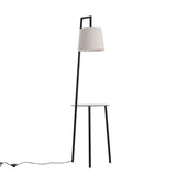 Floor lamp setup with linen lampshade and round metal tray table, black finish.
