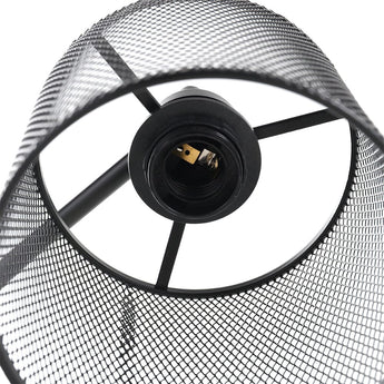 Detail of iron mesh lampshade and bulb socket on black floor lamp
