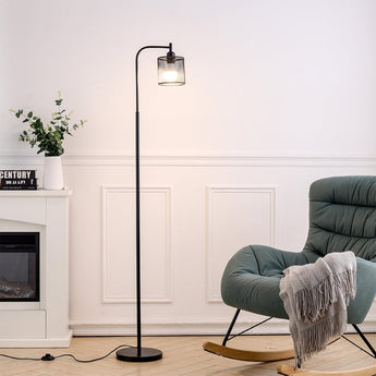 Black industrial floor lamp with metal mesh shade and exposed bulb inside