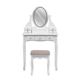 White makeup vanity desk with oval mirror and drawers, plus cushioned stool