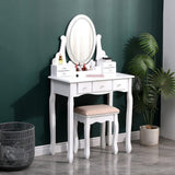 White makeup vanity desk set with oval mirror, multiple drawers, and cushioned stool