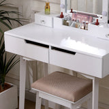 White makeup desk with lighted mirror bulbs, drawer fronts, and padded stool