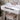 White makeup desk with lighted mirror bulbs, drawer fronts, and padded stool