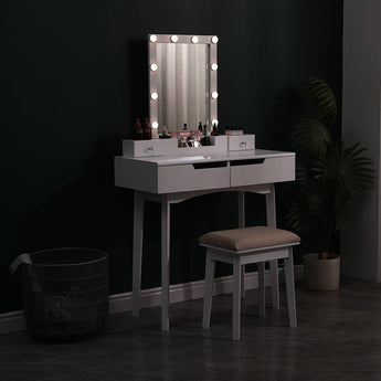 White vanity table with illuminated mirror, two drawers, and upholstered stool