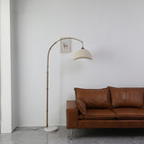 Front view of fabric floor lamp with cream dome shade and arched bronze frame