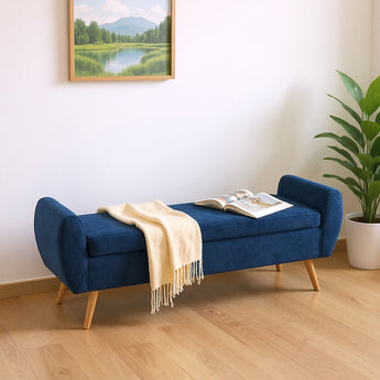 Blue chenille storage bench with hinged lid and throw blanket draped on seat