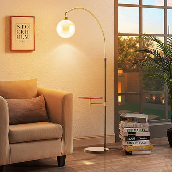 Modern arc floor lamp with glass globe bulb and wood tray, black pole, gold accents