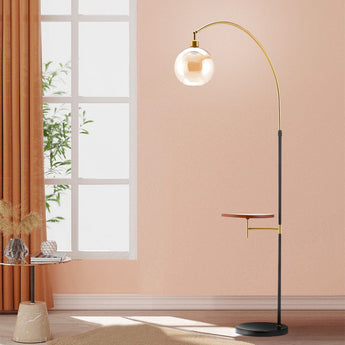 Arc floor lamp with globe shade, black stand and small wood tray on gold bracket