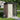 Brown and gray metal storage shed with cream front door panels and pent roof.