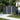 Metal garden storage shed, dark gray panel walls, central door opening, apex roof