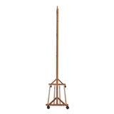 Bamboo garment rack with tall upright posts and caster wheels on base frame
