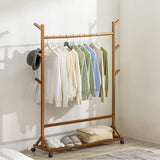 Bamboo garment rack with hanging bar, side pegs, hat holder, and wheels
