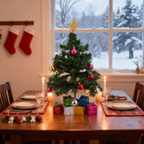 Mini artificial Christmas tree with gold star, pink and gold baubles, lights, gift boxes