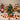 Mini artificial Christmas tree with gold star, red and green baubles, lights, gift boxes