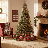 Artificial Christmas tree with warm lights and red ornaments on metal stand.